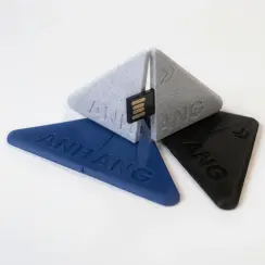 Drei dreieckige USB-Sticks in Blau, Weiß und Schwarz, aufgefächert auf weißem Hintergrund.